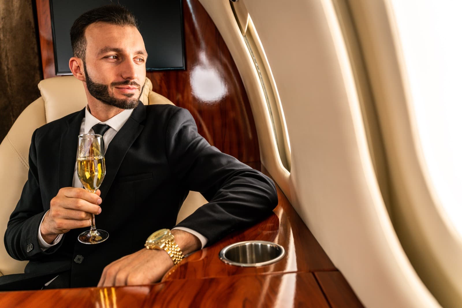 A midsize private jet parked on the ramp at a small upstate New York airport under summer afternoon light