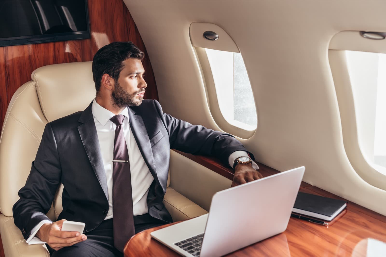 A super-midsize business jet parked on a quiet FBO ramp at dusk with the cabin door open and airstair down